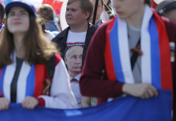 epa05938296 A man with portrait of Russian President Vladimir Putin on t-shirt attends the May Day demonstration on Red Square in Moscow, Russia, 01 May 2017. According to reports, more then 100,000 citizens of Moscow attended the rally. Labor Day or May Day is observed all over the world on the first day of the May to celebrate the economic and social achievements of workers and fight for laborers rights.  EPA/SERGEI ILNITSKY