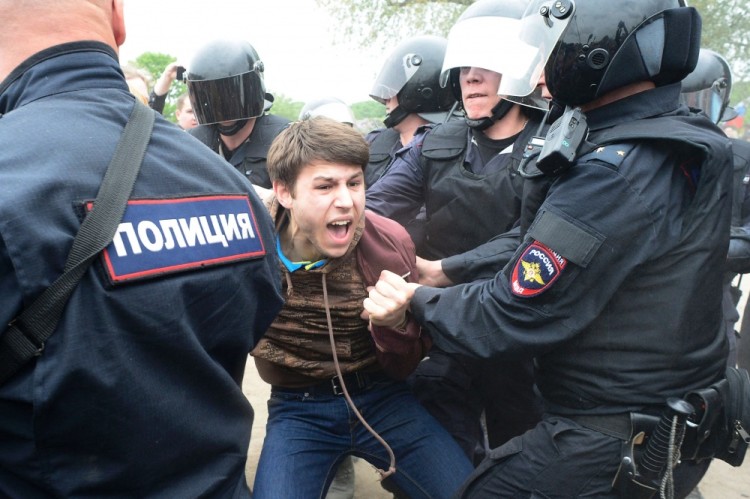 Russian police officers detain a participant of an unauthorized opposition rally in Saint Petersburg on June 12, 2017. Over 200 people were detained on June 12, 2017 by police at opposition protests called by Kremlin critic Alexei Navalny, said a Russian NGO tracking arrests. "About 121 people were detained in Moscow up to this point. In Saint-Petersburg - 137," OVD-Info group, which operates a detention hotline, wrote on Twitter. / AFP PHOTO / OLGA MALTSEVA