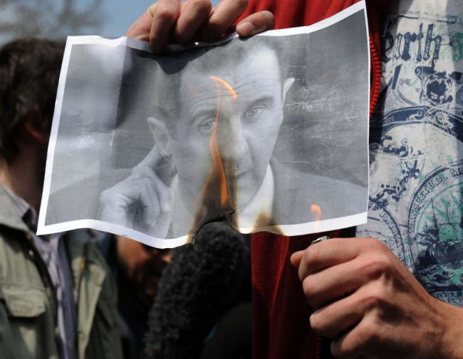 Участники протестов в Сирии сжигают портрет Башара Асада в апреле 2011 года. Фото AFP/Scanpix