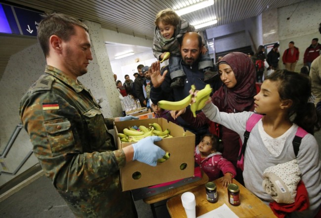 Немецкий солдат раздает еду беженцам в Берлине. Фото Reuters/Scanpix