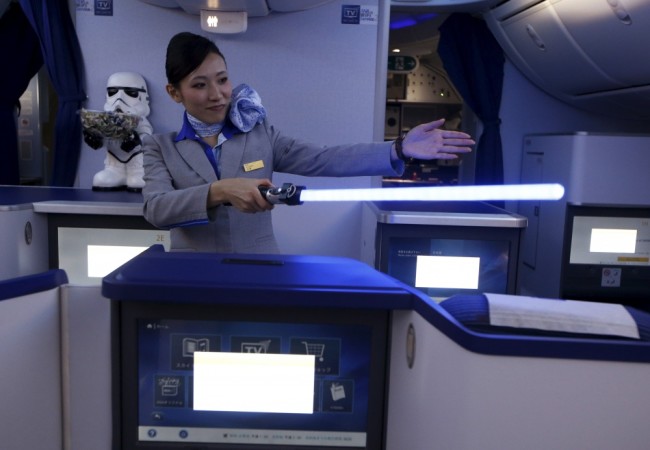 Стюардесса тематического лайнера рассказывает правила поведения на борту при помощи лазерного меча из "Звездных воин". Сингапур. Фото REUTERS/Scanpix
