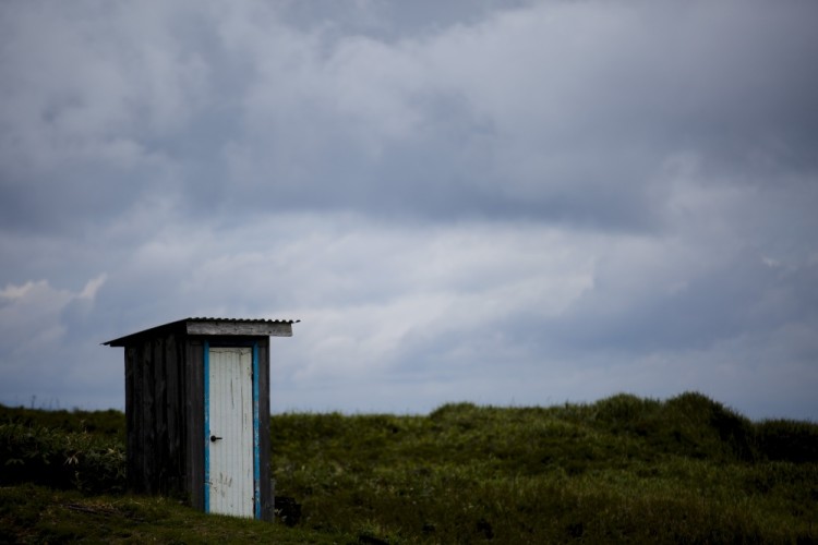A toilet stands in a field on private property in the town of Yuzhno-Kurilsk on Kunashir Island which is part of the Kuril Islands group in Russia, September 16, 2015. Some 2.4 billion people around the world don't have access to decent sanitation and more than a billion are forced to defecate in the open, risking disease and other dangers, according to the United Nations. The UN says that while there is sufficient fresh water on the planet for everyone, "bad economics and poor infrastructure" mean that every year millions of people - most of them children - die from diseases linked to poor sanitation, unhygienic living conditions and lack of clean water supplies. To mark World Toilet Day on November 19, Reuters photographers captured pictures of toilets in cities, towns and villages around the globe. REUTERS/Thomas Peter PICTURE 44 OF 45 FOR WIDER IMAGE STORY: "AROUND THE WORLD IN 45 TOILETS".SEARCH "REUTERS OUTHOUSE" FOR ALL IMAGES.