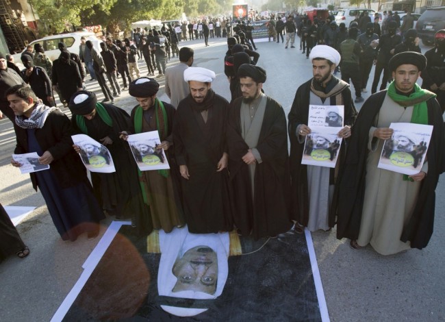 Шиитские священники топчут портрет саудовского короля в знак протеста против казни шейха Нимра ан-Нимра. Фото REUTERS/Scanpix