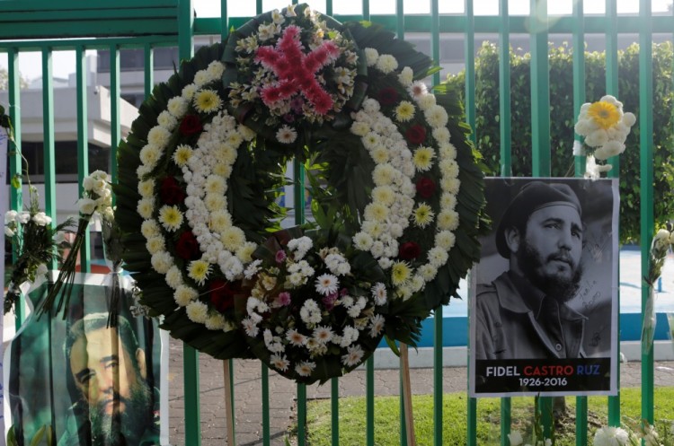 A wreath is seen between pictures of Fidel Castro during a tribute ceremony, following the announcement of the death of the Cuban revolutionary leader, outside the Cuban Embassy in Mexico City, Mexico, November 27, 2016. REUTERS/Henry Romero