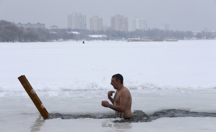 A man takes a dip in icy waters of a lake during Orthodox Epiphany celebrations in Minsk, Belarus January 19, 2017.  REUTERS/Vasily Fedosenko