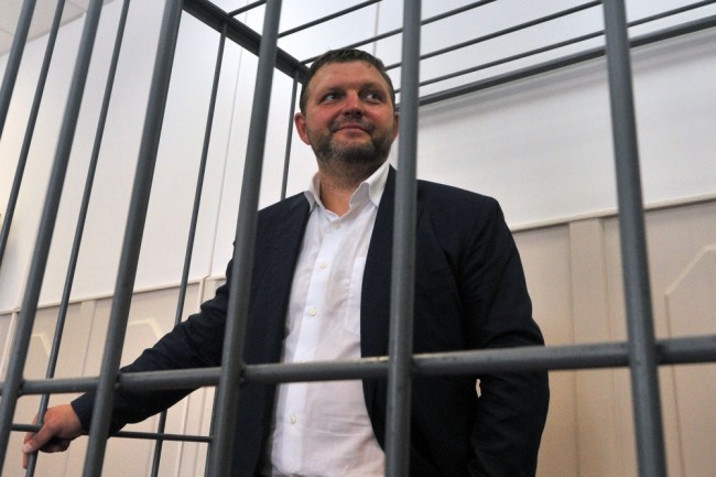 Kirov Region Governor Nikita Belykh, accused by Russia's Investigative Committee of accepting a bribe of 400,000 euros ($447,000), looks out from a defendants' cage during a hearing at the Basmanny district court in Moscow on June 25, 2016. / AFP PHOTO / Andrei MAKHONIN