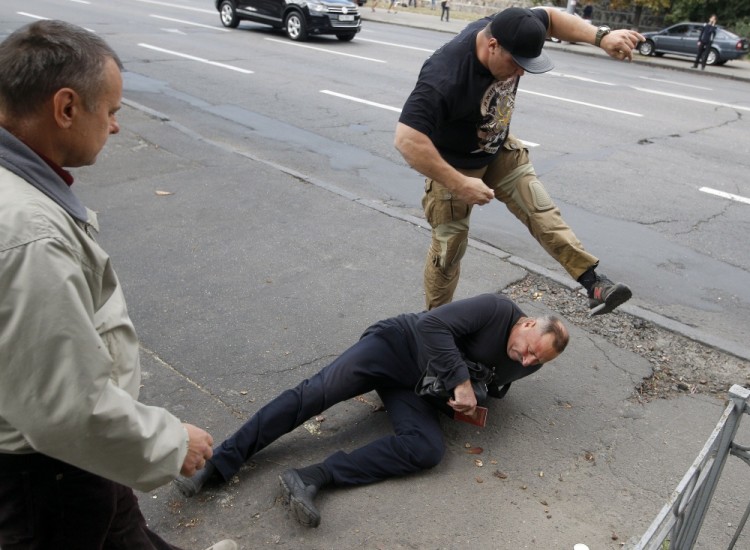 Радикалы избивают мужчину у здания российской дипмиссии. Фото AFP/Scanpix