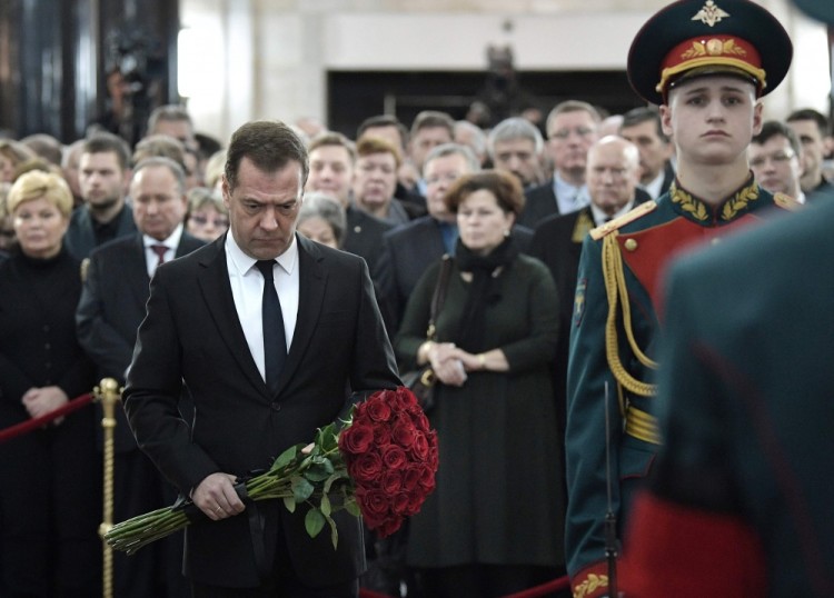Russian Prime Minister Dmitry Medvedev (L) pays his respects to killed Russian Ambassador to Turkey Andrei Karlov, during the funeral ceremony at the Russian Foreign Ministry in Moscow on December 22, 2016. President Vladimir Putin on December 22 bade farewell to Andrei Karlov at a packed memorial ceremony in Moscow for the diplomat who was assassinated in Turkey by an off-duty policeman. / AFP PHOTO / SPUTNIK / Ekaterina SHTUKINA