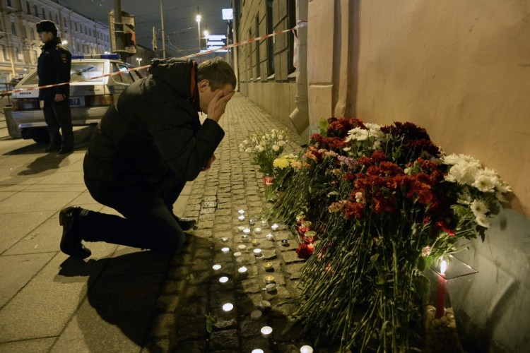 A man reacts as he places flowers in memory of victims of the blast in the Saint Petersburg metro outside Technological Institute station on April 3, 2017. Ten people were killed and several more injured Monday after an explosion rocked the metro system in Russia's second city Saint Petersburg, and authorities launched a probe into suspected "act of terror". / AFP PHOTO / Olga MALTSEVA