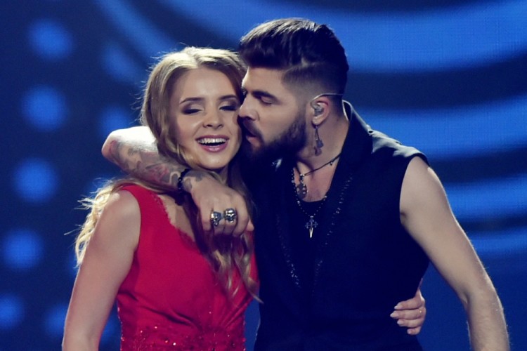 Romanian singer representing Romania with the song "Yodel it" Ilinca Bacila aka Ilinca (L) and Romanian singer Alex Florea (R) kisse as they perform on stage during the final of the 62nd edition of the Eurovision Song Contest 2017 Grand Final at the International Exhibition Centre in Kiev, on May 13, 2017. / AFP PHOTO / SERGEI SUPINSKY