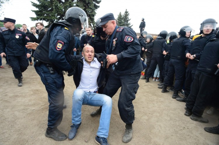 Russian police officers detain a participant of an unauthorized opposition rally in the centre of Saint Petersburg on June 12, 2017.  Over 200 people were detained on June 12, 2017 by police at opposition protests called by Kremlin critic Alexei Navalny, said a Russian NGO tracking arrests. "About 121 people were detained in Moscow up to this point. In Saint-Petersburg - 137," OVD-Info group, which operates a detention hotline, wrote on Twitter. / AFP PHOTO / OLGA MALTSEVA