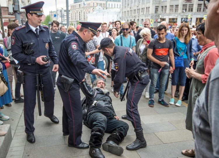 Russian police officers detain a participant of an unauthorized opposition rally in Tverskaya street in central Moscow on June 12, 2017.  Over 200 people were detained on June 12, 2017 by police at opposition protests called by Kremlin critic Alexei Navalny, said a Russian NGO tracking arrests. "About 121 people were detained in Moscow up to this point. In Saint-Petersburg - 137," OVD-Info group, which operates a detention hotline, wrote on Twitter.  / AFP PHOTO / Mladen ANTONOV