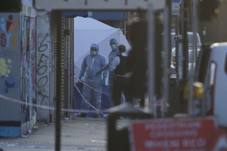 Forensic investigators work the scene in the Finsbury Park area of north London after a vehichle hit pedestrians, on June 19, 2017.  One man was killed and eight people hospitalised when a van ran into pedestrians near a mosque in north London in an incident that is being investigated by counter-terrorism officers, police said on Monday. The 48-year-old male driver of the van "was found detained by members of the public at the scene and then arrested by police," a police statement said.  / AFP PHOTO / Daniel LEAL-OLIVAS
