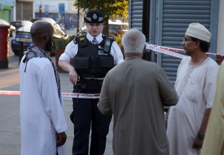 A police officer talsk with residents in the Finsbury Park area of north London after a vehichle hit pedestrians, on June 19, 2017.  One man was killed and eight people hospitalised when a van ran into pedestrians near a mosque in north London in an incident that is being investigated by counter-terrorism officers, police said on Monday. The 48-year-old male driver of the van "was found detained by members of the public at the scene and then arrested by police," a police statement said.  / AFP PHOTO / Daniel LEAL-OLIVAS