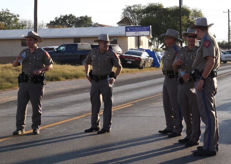 Police block a road in Sutherland Springs, Texas, on November 5, 2017, after a mass shooting at the the First Baptist Church (rear). "There are 26 lives that have been lost. We don't know if that number will rise or not, all we know is that's too many, and this will be a long, suffering mourning for those in pain," Texas Governor Greg Abbott said during a press conference.  / AFP PHOTO / SUZANNE CORDEIRO