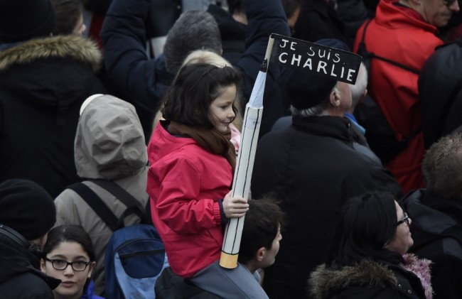 Девочка держит карандаш с плакатом: "Я - Шарли" . Фото AFP PHOTO/Scanpix