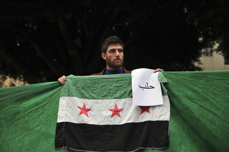В Бейруте на улицы вынесли флаги сирийский оппозиционных сил и листы, на которых по-арабски написано "Алеппо". Фото: AP / Scanpix