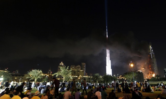 Люди, пришедшие смотреть на новогодний салют в центре Дубая, наблюдают за пожаром в гостиные. Фото AFP PHOTOScanpix