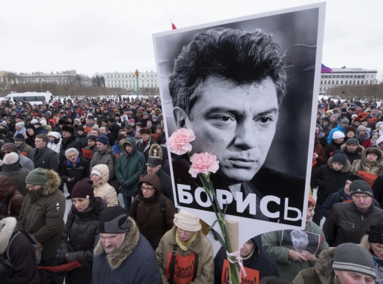 People gather in memory of opposition leader Boris Nemtsov, portrait in center, in St. Petersburg, Russia, Sunday, Feb. 26, 2017. Russians have taken to the streets of downtown Moscow and St. Petersburg to mark two years since Nemtsov was gunned down outside the Kremlin. (AP Photo/Dmitri Lovetsky)