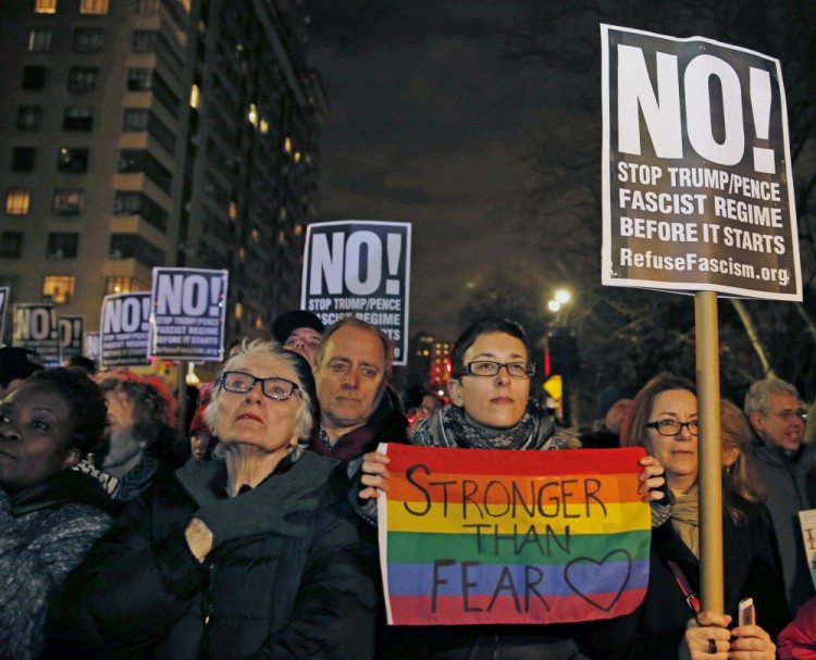 Protestors hold signs of "No!" as they listen to speakers at an anti-Trump rally hosted by filmmaker Michael Moore in front of the Trump International Hotel, Thursday, Jan. 19, 2017, in New York. President-elect Donald Trump, a New Yorker, is scheduled to take the oath of office Friday in Washington. (AP Photo/Kathy Willens)