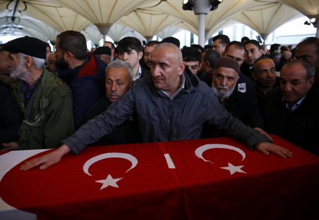 Родственники погибших в теракте над украшенном турецкой символикой гробом, фото Reuters/Scanpix