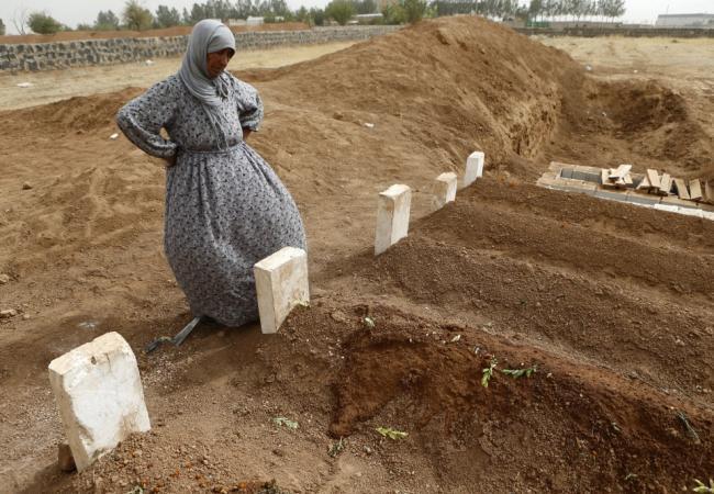 Сирийская женщина у могилы своего сына, погибшего в бою с боевиками ИГИЛ. Фото Reuters/Scanpix