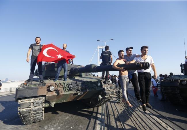 Жители Стамбула рядом с танком мятежников, сдавшемся властям. Фото: REUTERS / Scanpix