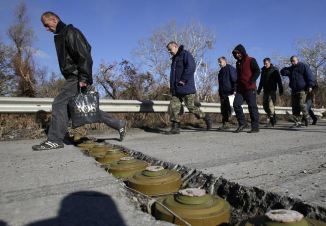 Украинские военнослужащие перешагивают через противотанковые мины в ходе их обмена на пленных из непризнанных республик. Фото: AFP / Scanpix
