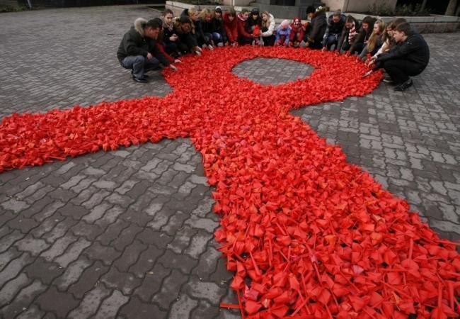 Красная лента — принятый во всем мире символ борьбы со СПИД. Фото: Reuters / Scanpix