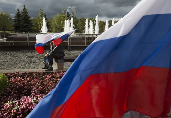 Фото: AP/Scanpix. Участник акции в День флага России