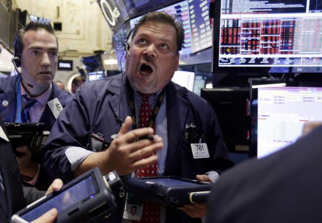 Трейдер NYSE Джон Сантъяго наблюдает за движением индексов при открытии торгов. Понедельник, 24 августа. Фото AP/Scanpix