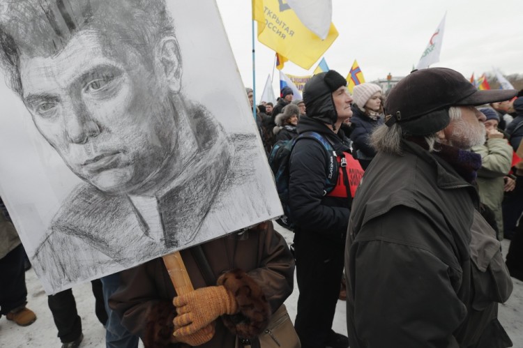 epa05816141 People participate in a memorial march for Boris Nemtsov (seen on poster L) to mark the second anniversary of his murder, in St. Petersburg, Russia, 26 February 2017. Nemtsov, a liberal opposition leader and sharp critic of Russian president Vladimir Putin, was killed on 27 February 2015 by a group of Chechen military servicemen in Moscow.  EPA/ANATOLY MALTSEV