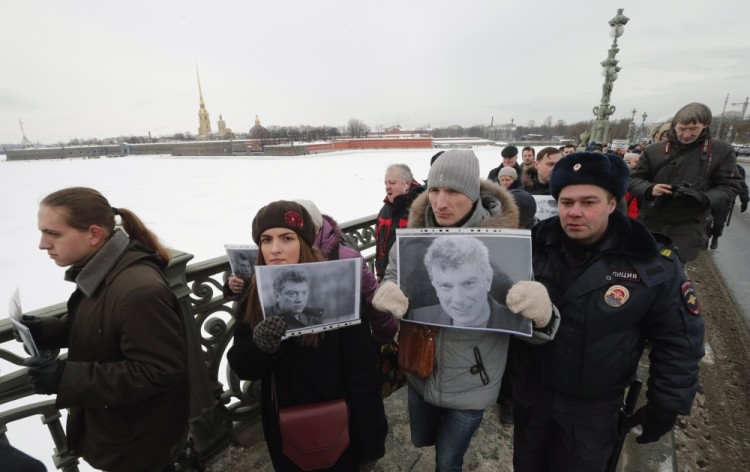 epa05816150 People participate in a memorial march for Boris Nemtsov (seen on posters) to mark the second anniversary of his murder, in St. Petersburg, Russia, 26 February 2017. Nemtsov, a liberal opposition leader and sharp critic of Russian president Vladimir Putin, was killed on 27 February 2015 by a group of Chechen military servicemen in Moscow.  EPA/ANATOLY MALTSEV
