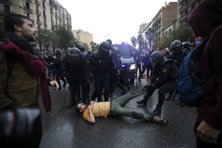epa06237334 Spanish National riot policemen evict a man during clashes between the people gathered outside the Ramon Llull school and police forces during the '1-O Referendum' in Barcelona, Catalonia, on 01 October 2017. National Police officers and Civil guards have been deployed in Barcelona to prevent the people from entering to the polling centers and vote in the Catalan independence referendum, that has been banned by the Spanish Constitutional Court. The police action has provocked clashes between pro-independence people and the police forces.  EPA/Alberto Estevez