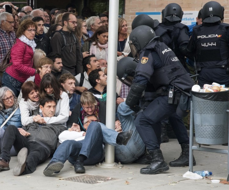 epa06237426 Catalan people are being moved outside at a polling center set at a health clinic clash with Spanish National Police officers after police forces seized ballot boxes during the '1-O Referendum' in Cappont, Lleida, Catalonia, northeastern Spain, on 01 October 2017. National Police officers and Civil guards have been deployed to seize voting material and to prevent the people from entering to the polling centers and vote in the Catalan independence referendum, that has been banned by the Spanish Constitutional Court, what has provocked clashes between pro-independence people and the police forces in some polling centers.  EPA/Adria Ropero