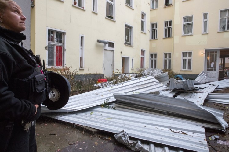 epa06296264 A police woman stands next to corrugated sheets fallen due to heavy squalls in the backyard of an apartment house in Berlin, Germany, 29 October 2017. Deep depression 'Herwart' caused several damages and injuries in Germany.  EPA/ALEXANDER BECHER