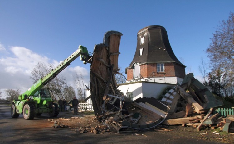 Workers remove the debris from a storm damaged wheat mill built in the year 1786 on October 29, 2017 as a storm hit many parts of Germany. At least three people died in a windstorm that hit central Europe early on on October 29, 2017, causing widespread power outages and traffic disruptions, rescuers said / AFP PHOTO / dpa / Wolfgang Runge / Germany OUT