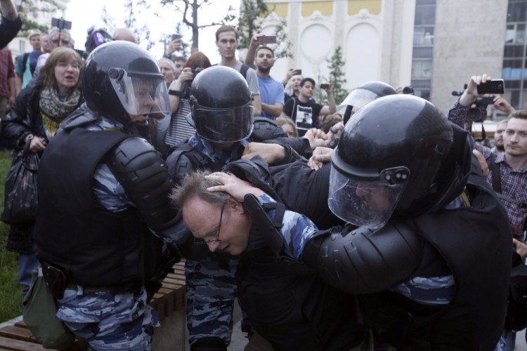 epa06024293 Russian police officers detain a participant of an unauthorized opposition rally in Tverskaya  street in central Moscow, Russia, on Russia Day, 12 June 2017. Russian liberal opposition leader and anti-corruption blogger Alexei Navalny has called his supporters to hold a protest in Tverskaya Street, which leads to the Kremlin, instead of the authorized by Moscow officials Sakharov avenue. Changing the location may provoke clashes with the police.  EPA/SERGEI CHIRIKOV