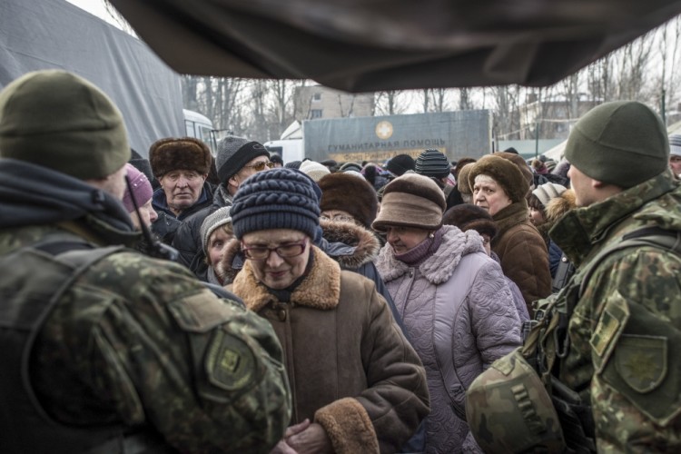 Local residents queue to receive aid at a humanitarian aid center in Avdiivka, eastern Ukraine, Wednesday, Feb. 1, 2017. Freezing residents of an eastern Ukraine town battered by an upsurge in fighting between government troops and Russia-backed rebels flocked to a humanitarian aid center Wednesday to receive food and warm up. (AP Photo/Evgeniy Maloletka)