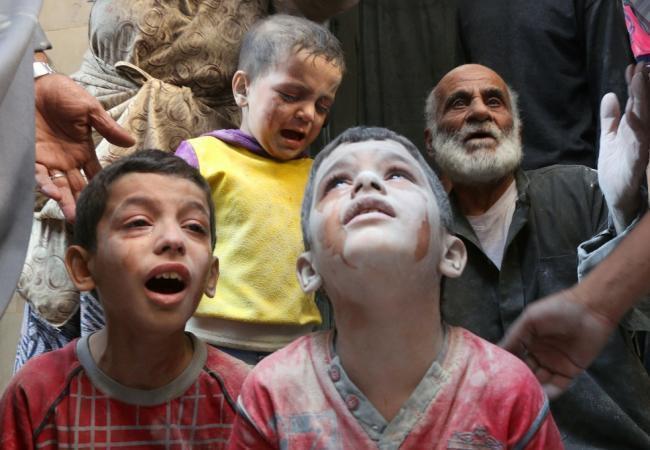 Сирийские дети в пыли разрушенных зданий. Фото TASS / Scanpix / Leta