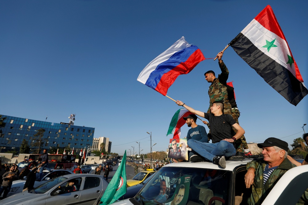 Сирийские протестующие с российским флагом. Фото REUTERS/Scanpix/LETA
