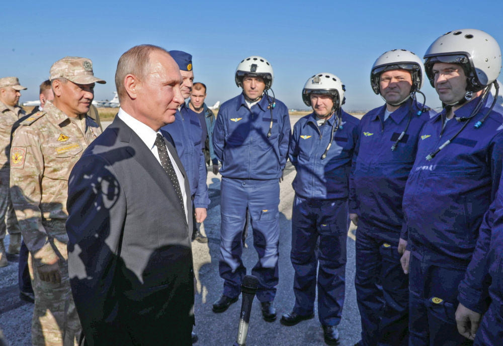 Президент Путин и министр обороны Шойгу встречаются с российскими пилотами во время визита на сирийскую авиабазу Хмеймим. Фото AFP/Scanpix/LETA