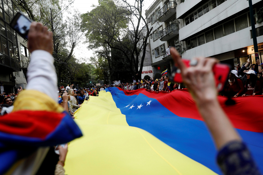 Флаг Венесуэлы во время акции протеста в поддержку лидера оппозиции  Хуана Гуаидо. Фото REUTERS/Scanpix/Leta
