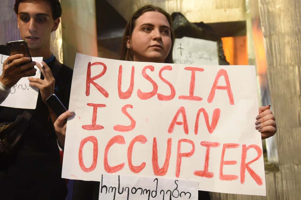 Участница акции протеста с плакатом «Россия — это оккупант» (англ.). Фото AFP/Scanpix/Leta