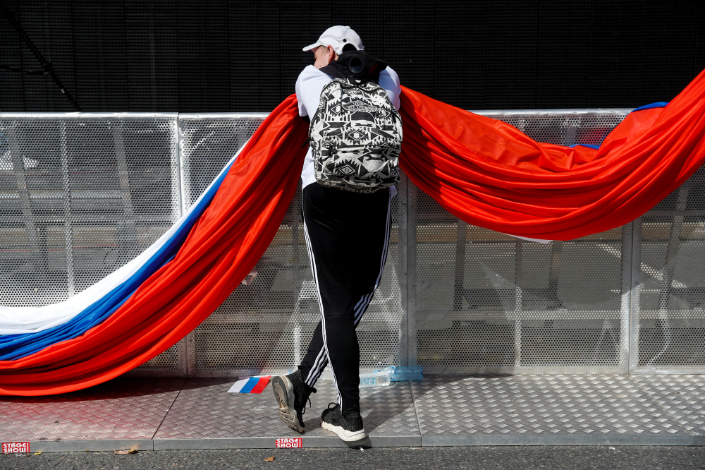 Мужчина держит российский флаг. Фото: Maxim Shemetov/TASS/Scanpix/Leta