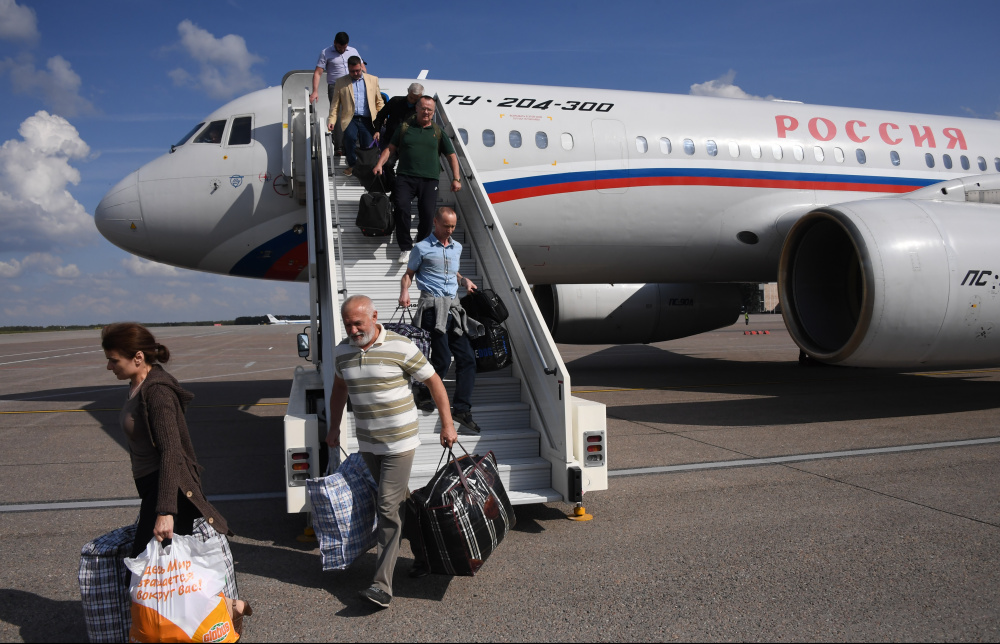 Прилетевшие россияне выходят из самолета. Фото Iliya Pitalev / Sputnik/Scanpix/Leta