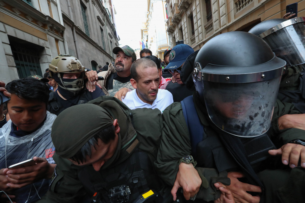 Одного из лидеров оппозиции Луиса Фернандо Камачо сопровождают полицейские после отставки президента Эво Моралеса. Фото: Martin Alipaz / TASS / Scanpix / Leta