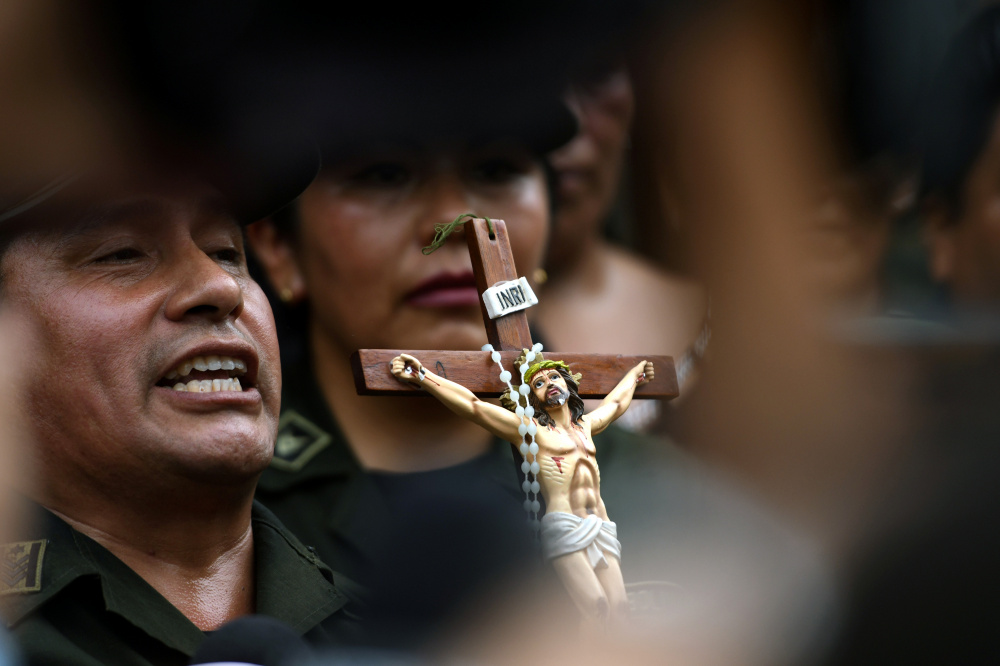 Сотрудник полиции держит распятие после объявления  Эво Моралеса об отставке. Фото: RODRIGO URZAGASTI / TASS / Scanpix / Leta
