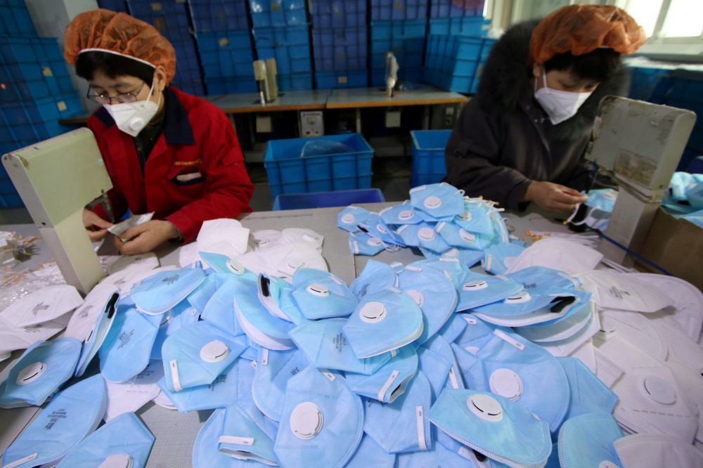 Рабочие делают защитные маски на заводе в Китае. Фото: CHINA DAILY / TASS / Scanpix / Leta