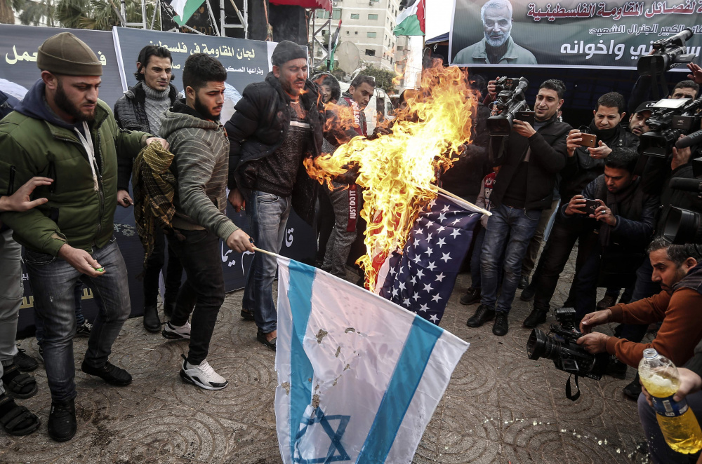 Палестинцы в Газе сжигают флаги Израиля и США в знак протеста против убийства генерала Сулеймани. Фото MAHMUD HAMS/AFP/Scanpix/LETA